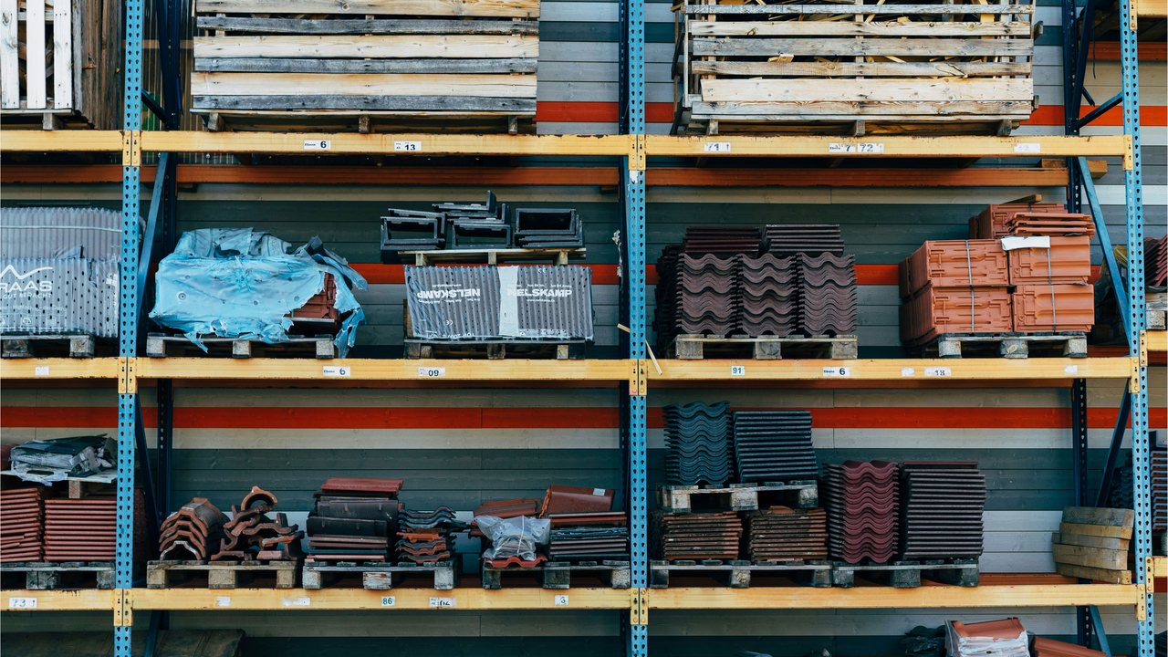Warehouse racking stacked with roof tiles, bricks and building supplies