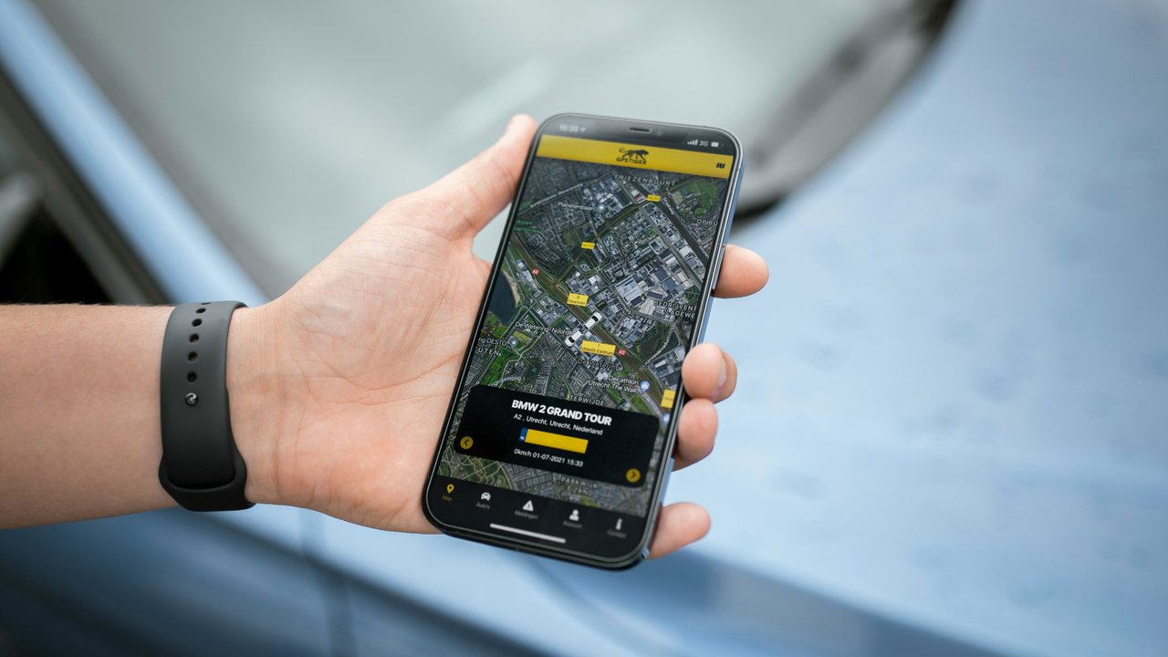 Hand holding a phone showing a vehicle tracking map