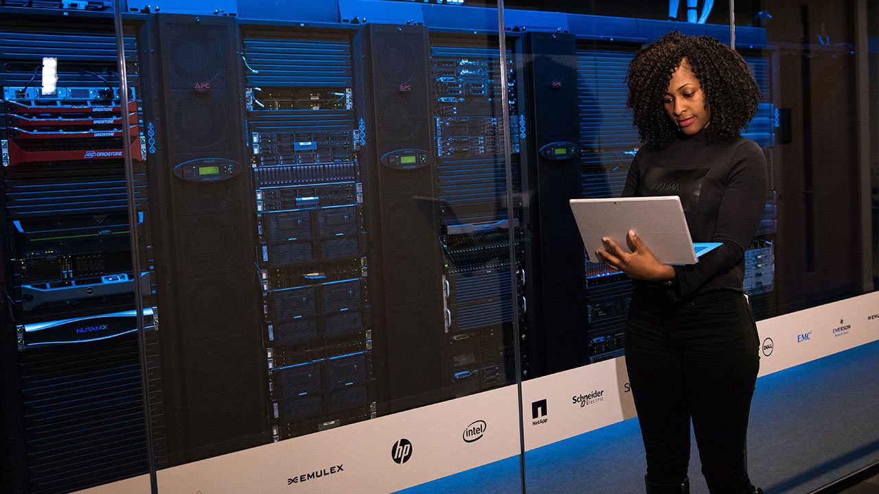 Engineer with a tablet checking server racks in a data centre